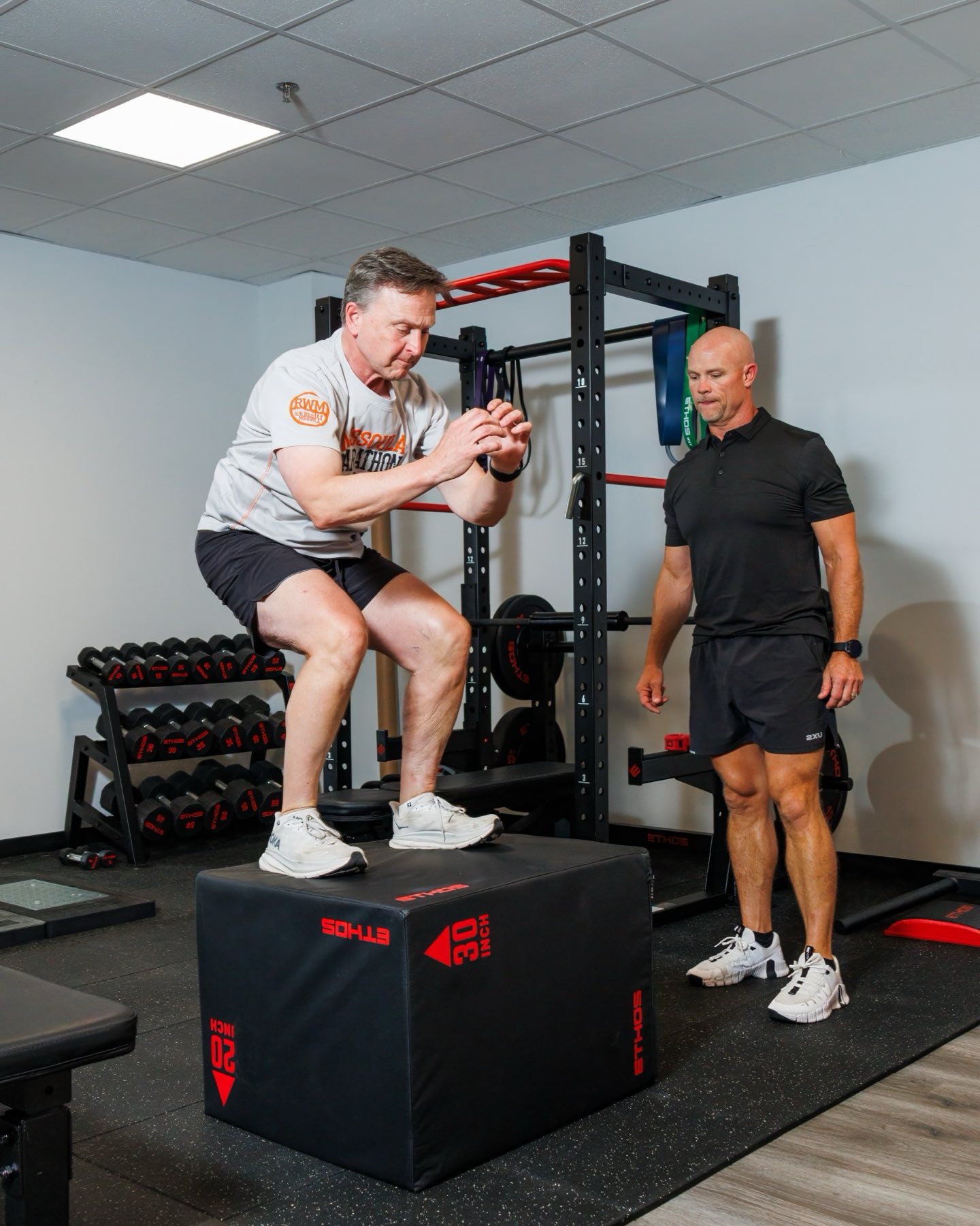 A member launching a coached box jump on the FINISH performance floor