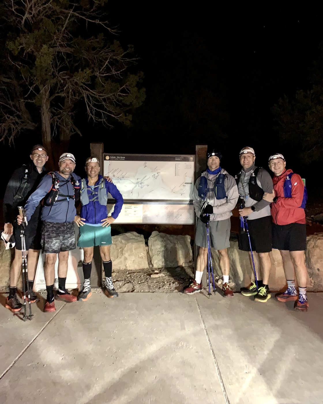 Kelly and five friends at the South Kaibab trailhead before dawn, headlamps on, setting out across the Grand Canyon