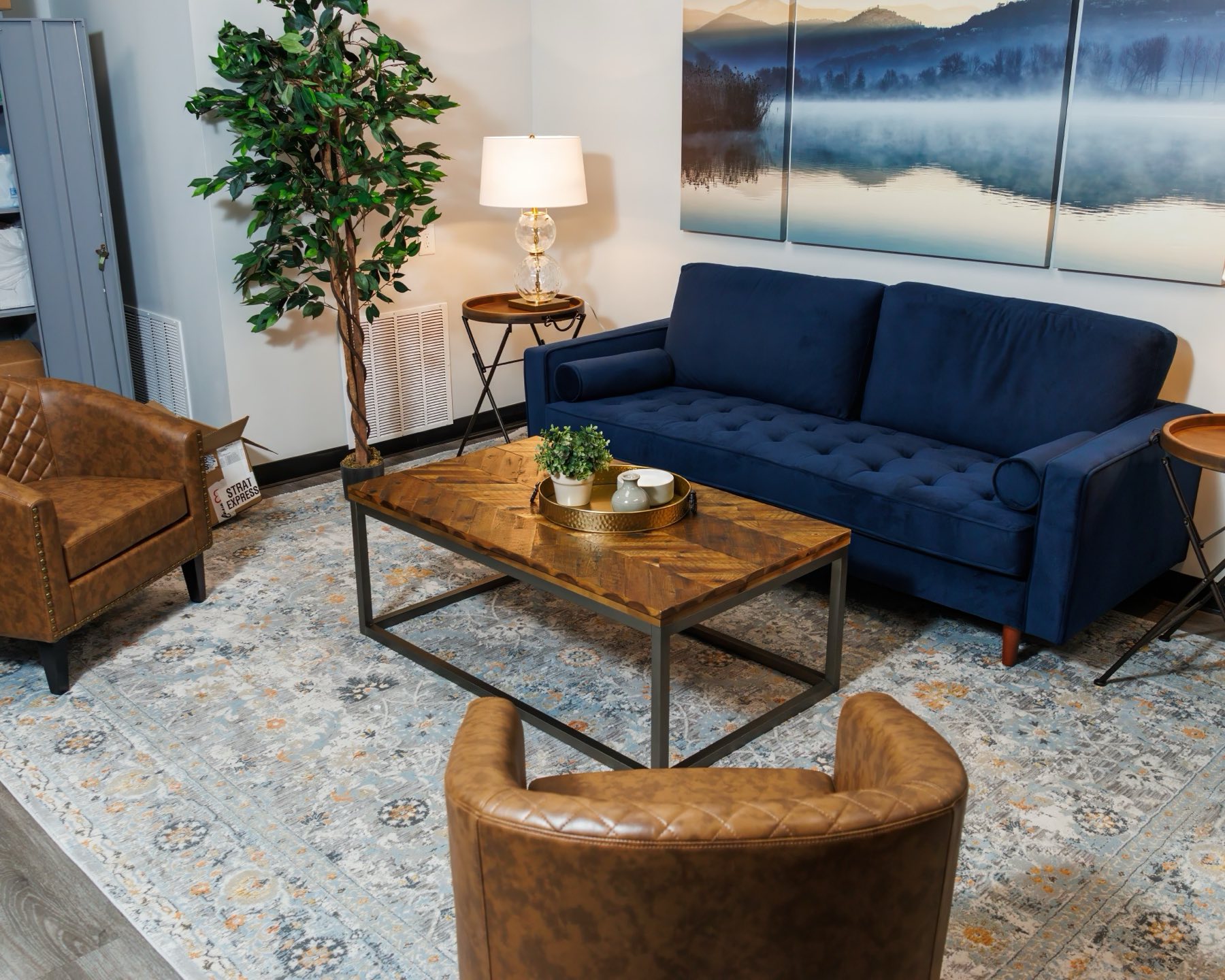 The FINISH Performance Health lounge — deep navy sofa, cognac leather chairs, and misty-mountain artwork
