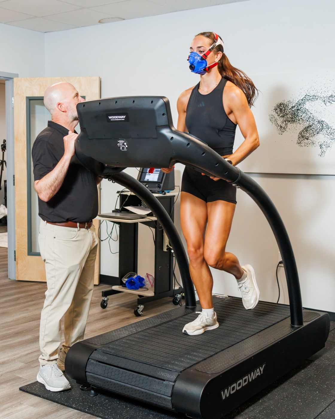 A VO2 max test in progress at FINISH — an athlete running masked on the treadmill while a clinician reads the numbers